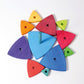 wooden pieces of a childs stacking toy are laid o a flat surface. each piece is triangular and has a hole in the middle.  The centre piece has an upright stick for the triangular pieces to be stacked on